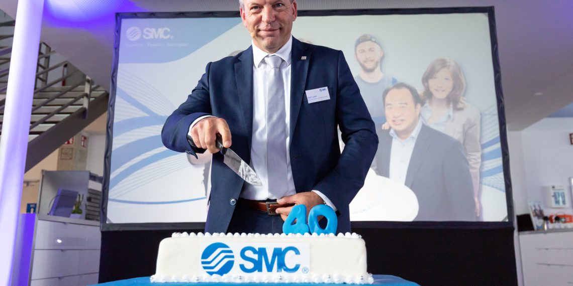 Ralf Laber, Geschäftsführer SMC Deutschland, schneidet beherzt die Geburtstagstorte an.
