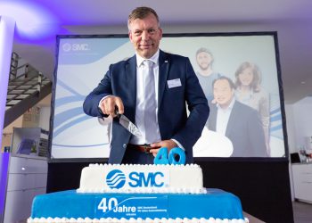 Ralf Laber, Geschäftsführer SMC Deutschland, schneidet beherzt die Geburtstagstorte an.