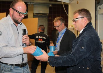 Ein blauer Topf bringt den Kreislauf in Schwung: Produktionsleiter Ulrich Lampe (links) erläuterte dem Lohner Bürgermeister Tobias Gerdesmeyer (rechts) im Rahmen der XXL-Werksführung, die Herstellung des neuen Reycling-Produktes. Bild: Pöppelmann