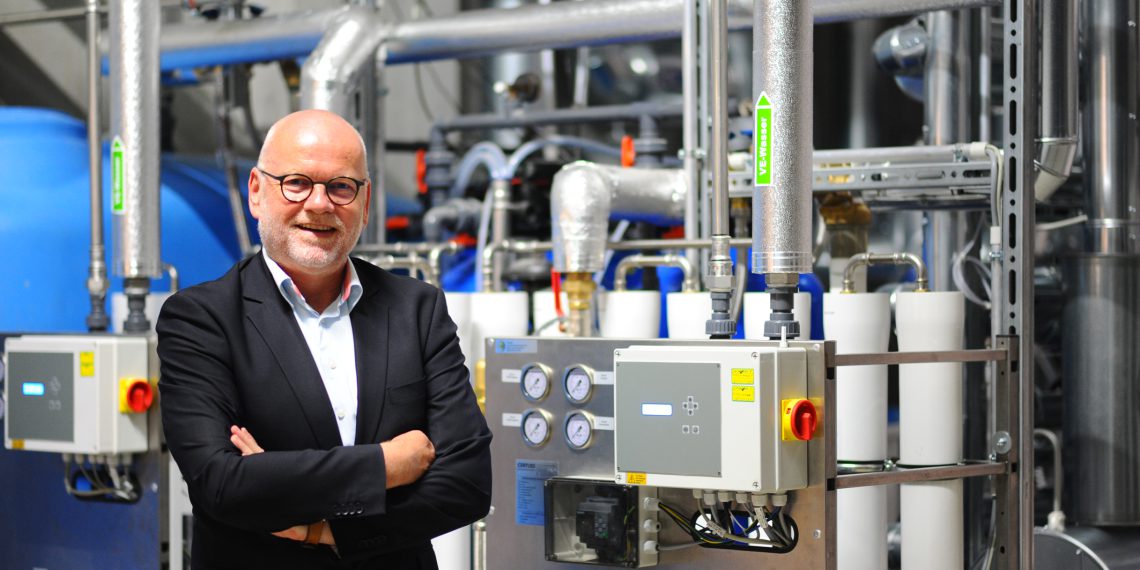 „Wenn man in der Lage ist, Energie sehr effizient zu nutzen, wird das über kurz oder lang ein bedeutender Wettbewerbsvorteil für einen Hersteller von Etiketten-Haftmaterial sein“ – Herma Geschäftsführer Dr. Thomas Baumgärtner vor der neuen dezentralen Dampferzeugungsanlage. (Bild: Herma)