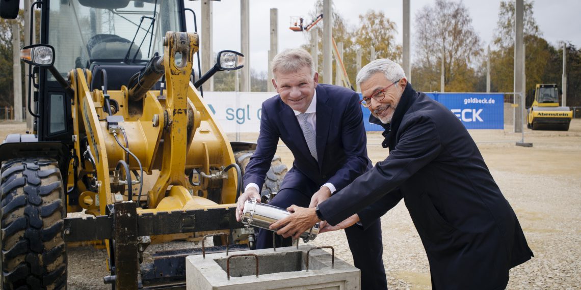 Jürgen Köhler, Vorstandsvorsitzender der SGL Carbon, und Furio Rozza, Geschäftsführer BSCCB, beim Einbringen der Zeitkapsel in das Fundament für das Logistikzentrum.