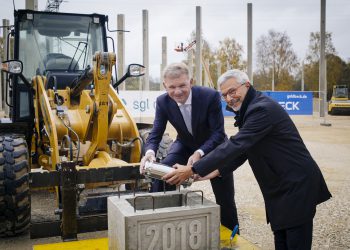 Jürgen Köhler, Vorstandsvorsitzender der SGL Carbon, und Furio Rozza, Geschäftsführer BSCCB, beim Einbringen der Zeitkapsel in das Fundament für das Logistikzentrum.
