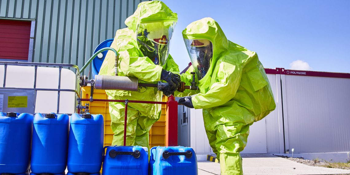 Ausgerüstet mit Sauerstoffflaschen, umgebungsluftunabhängigem Atemgerät und dem Chemikalienschutzanzug Tychem TK von DuPont dichten die Einsatzkräfte das Ammoniakleck mit einer Stahlmanschette ab.