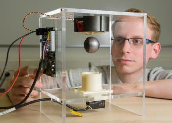 Ingenieur Niklas König aus dem Team von Matthias Nienhaus zeigt das Potenzial des sensorlosen Verfahrens: Es steuert eine Stahlkugel so präzise und geschickt an, dass diese frei auf und ab schwebt.